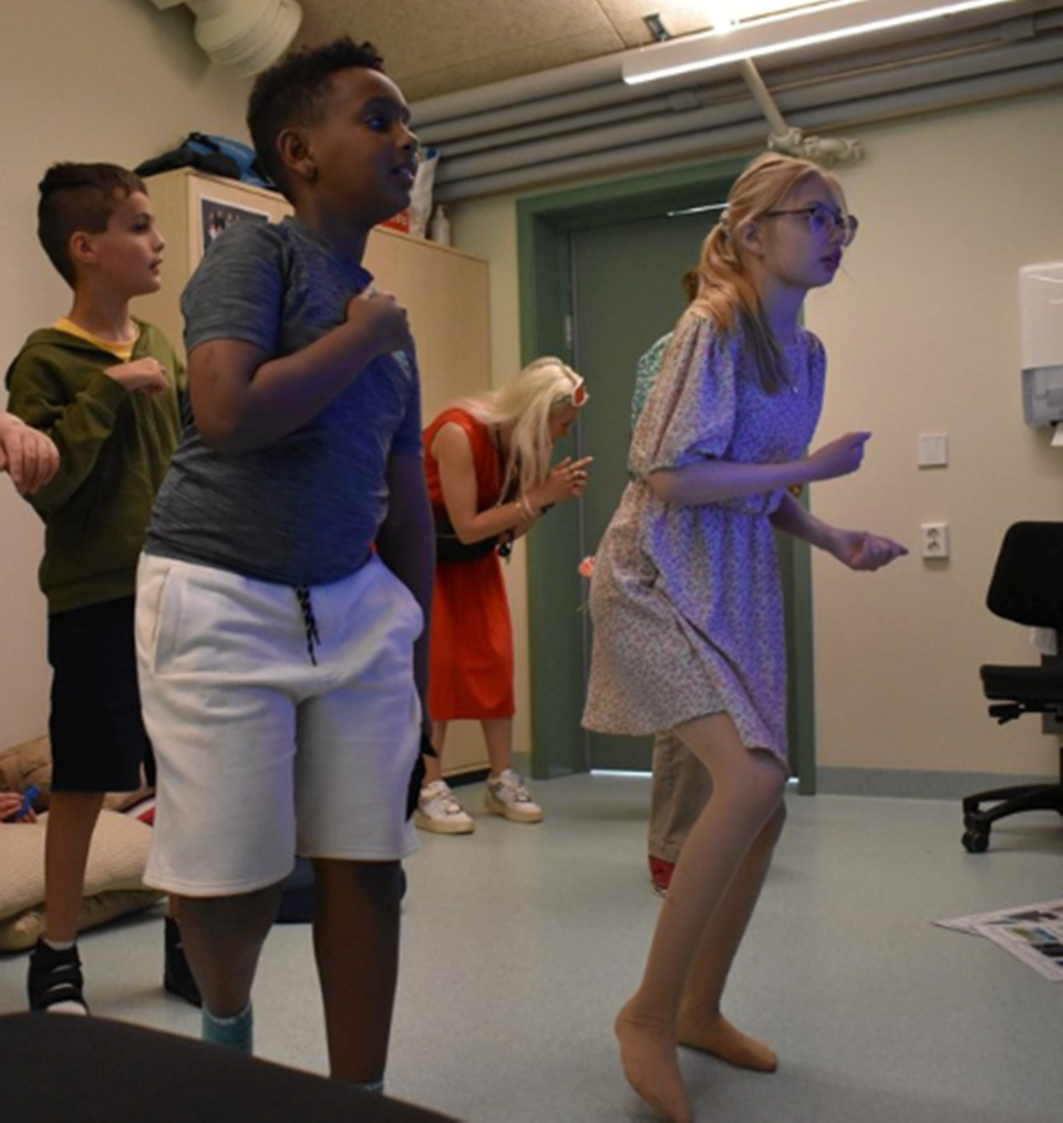 Barn danser i et klasserom. 