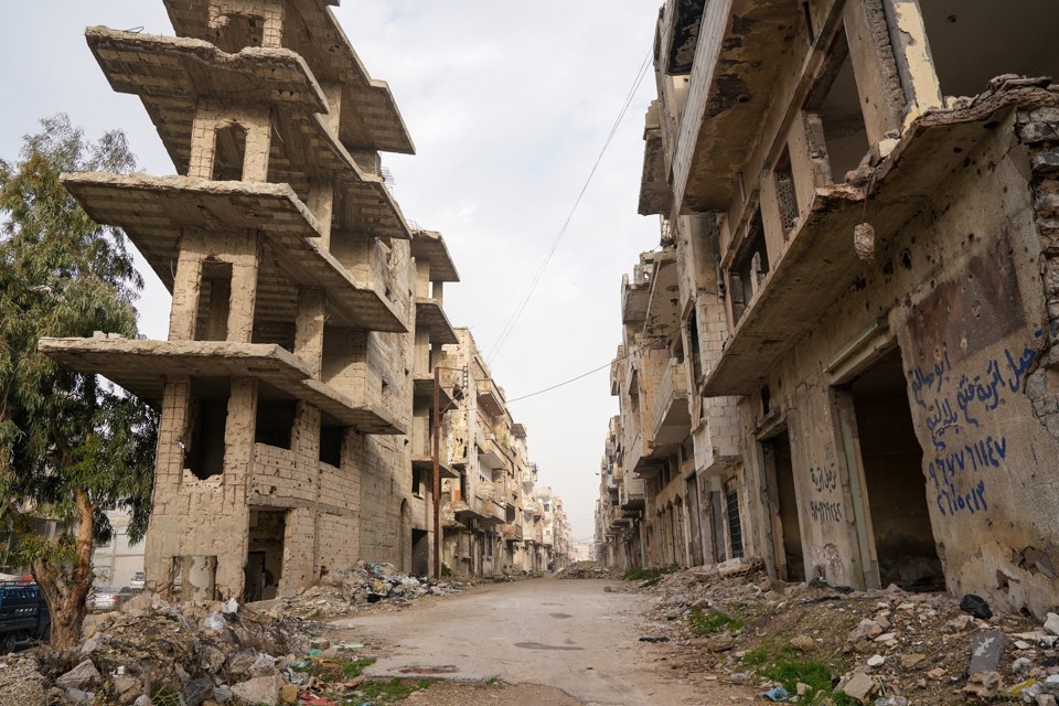 Utbombede bygninger langs en gate. 